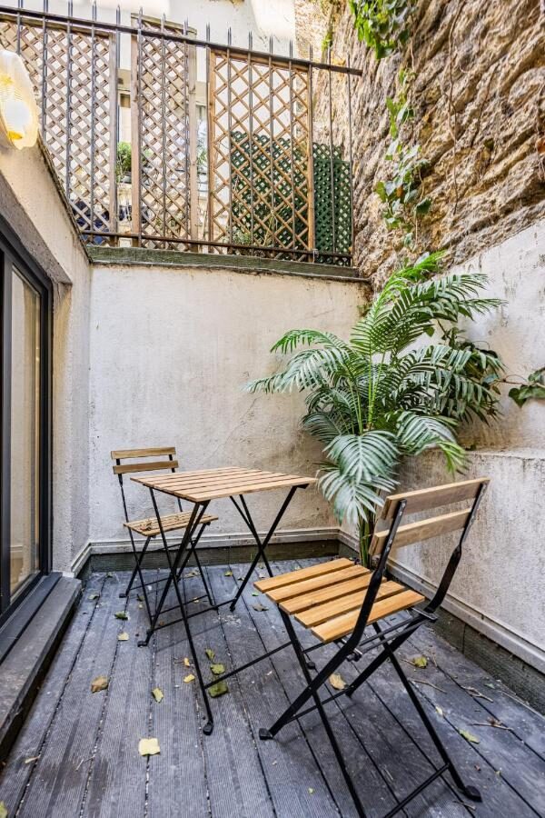 Terrasse privée arborée d'Au Cœur de Trocadéro avec table pour deux