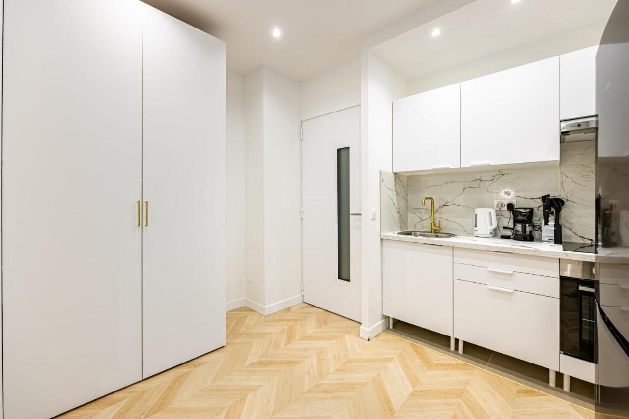 Cuisine blanche et parquet en chevrons d'Au Cœur de Trocadéro